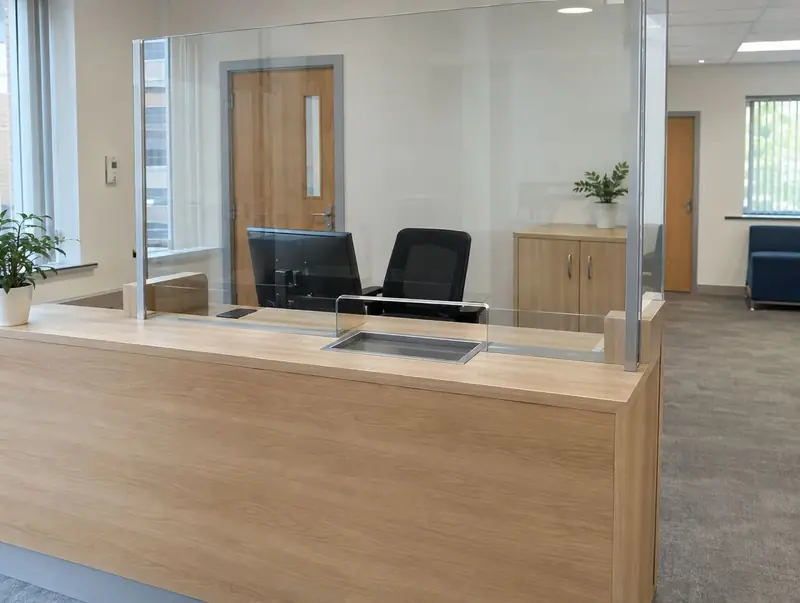 Reception desk with a full-height glass screen and a recessed document tray